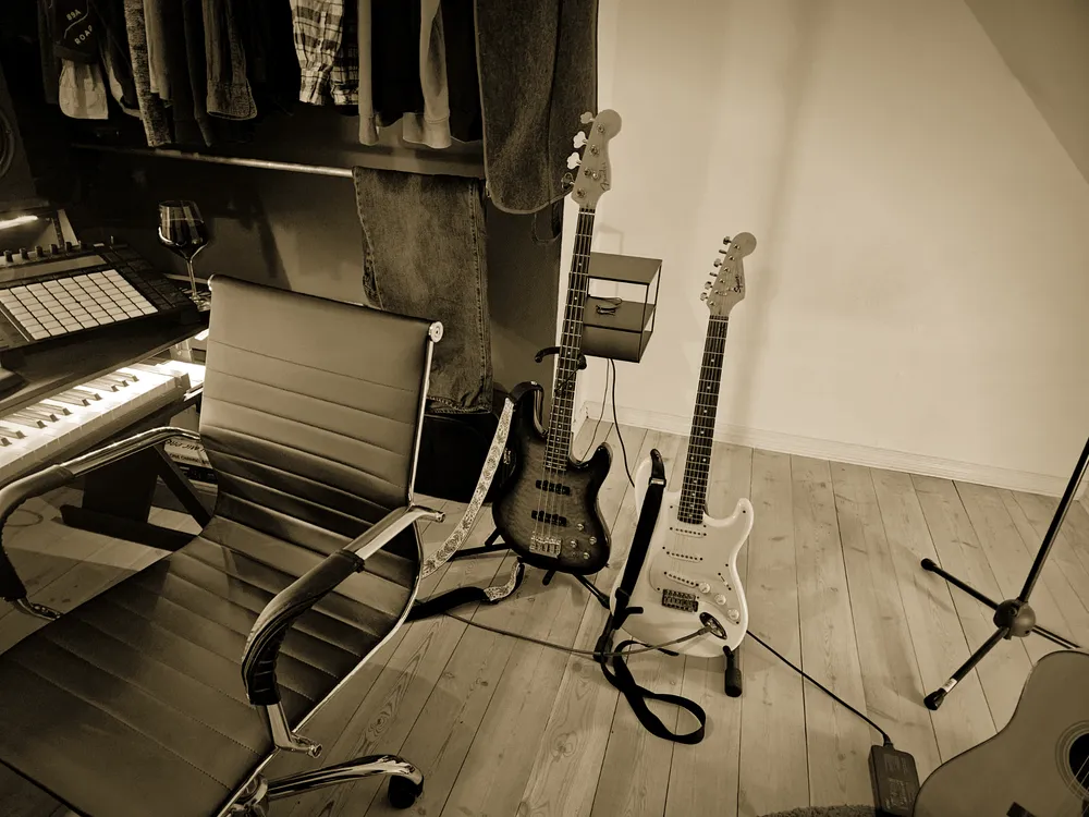 Bass and electric guitar on stands next to the producer's chair