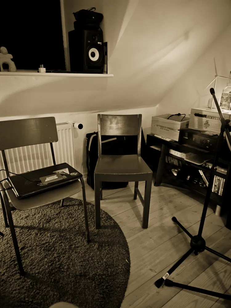 The vocal corner: a chair, headphones and a mic stand on the rug